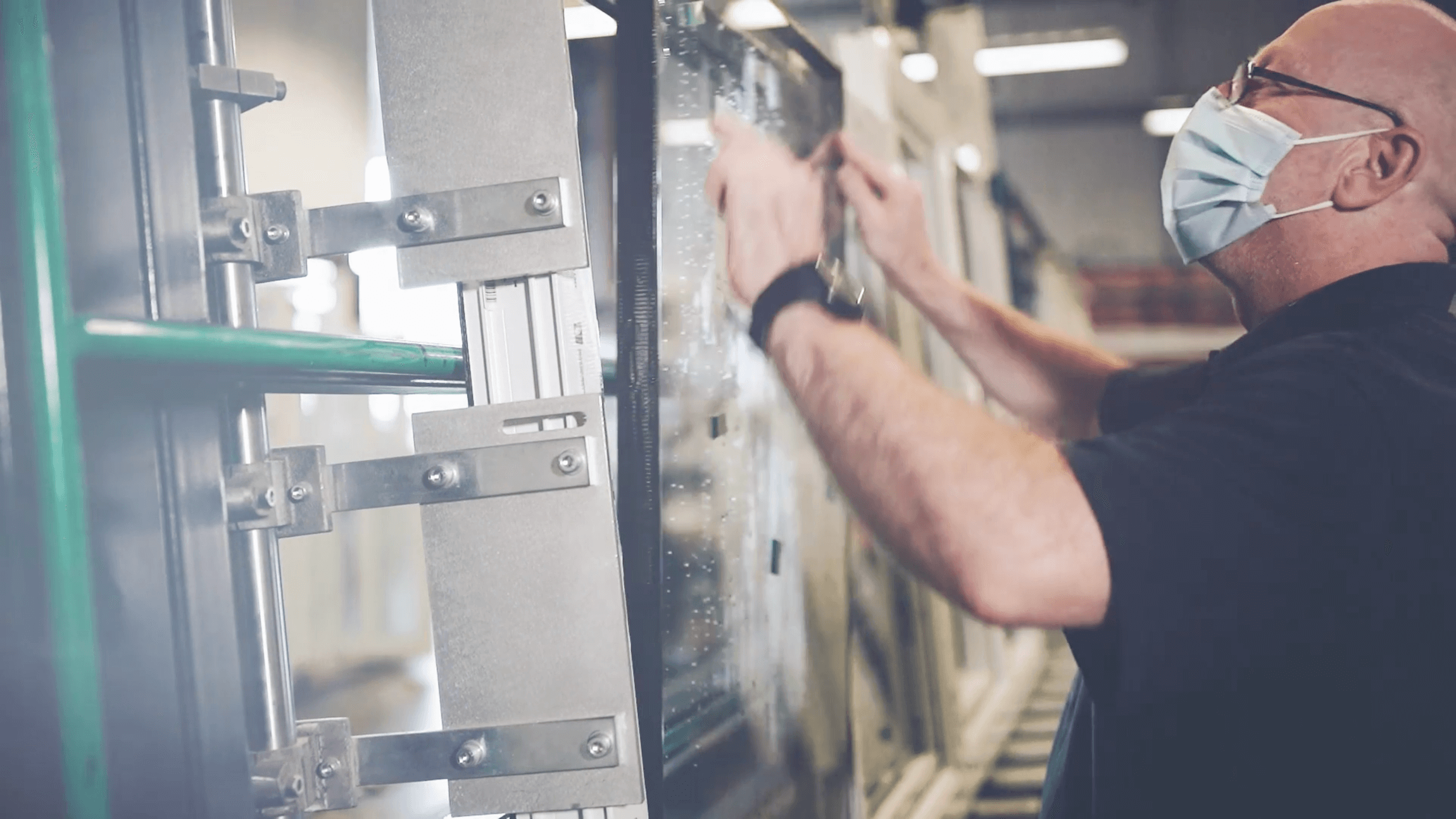 glass being fitted into frame by masked member of staff